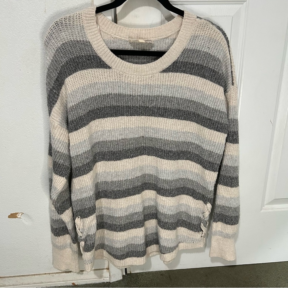 Woman’s, cream, light, grey, and dark grey striped knitted sweater.